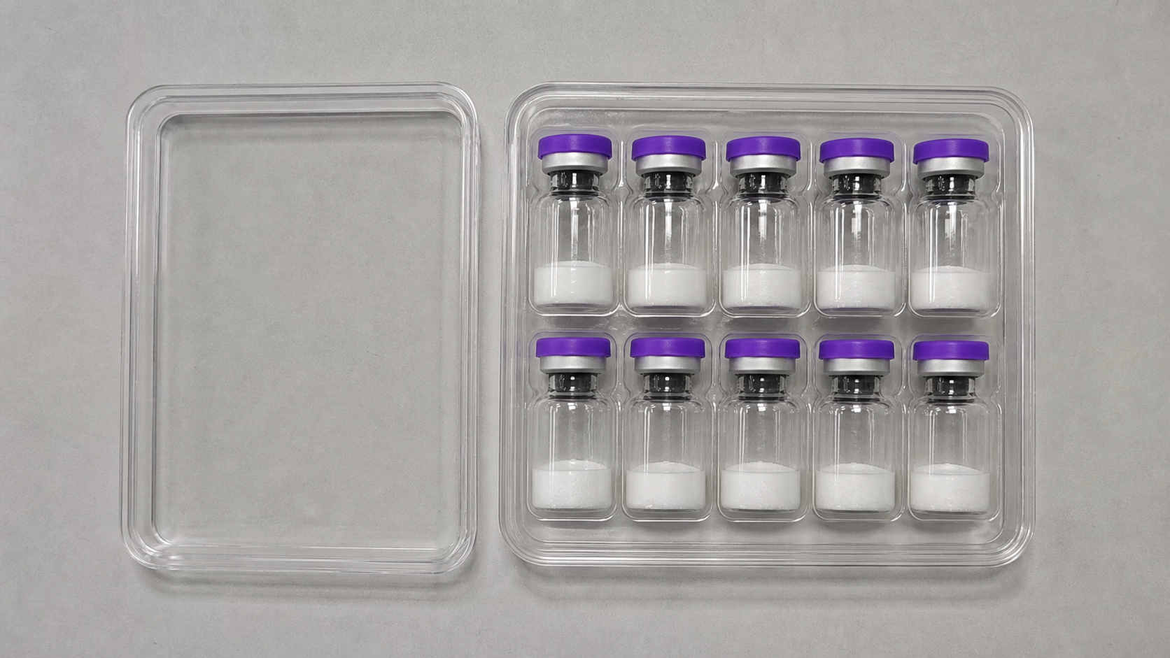 Top view of ten unlabeled lyophilized vials in a clear box